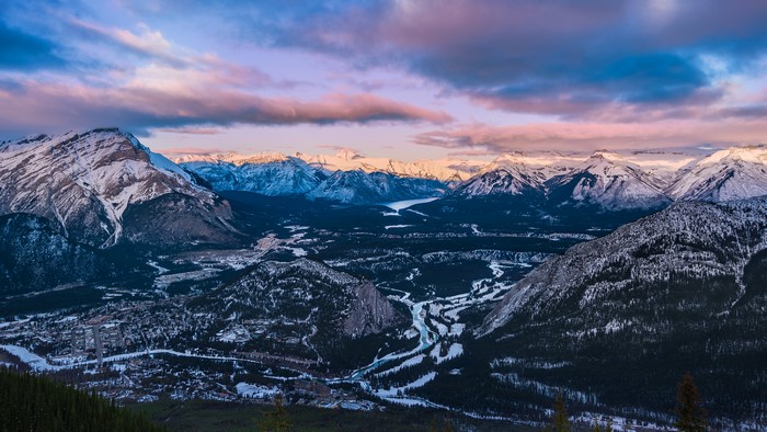 Snow-covered mountains and valley at sunset