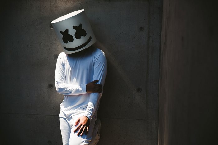 Marshmello DJ leaning against concrete wall