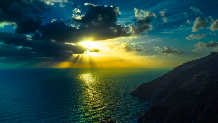Sunbeams over the ocean and mountains