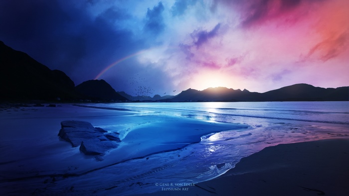 Rainbow over a beach at sunset with mountains
