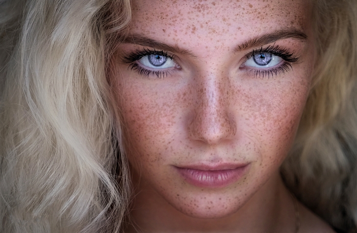 Close-up Portrait of a Blonde Woman with Blue Eyes and Freckles