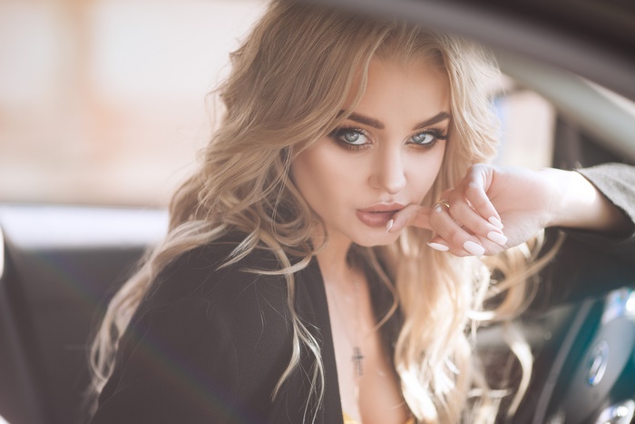 Blonde woman with blue eyes in a car