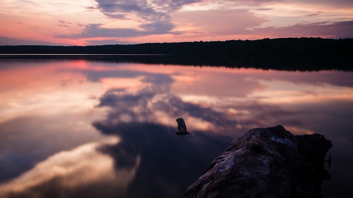 Sunset over a calm lake with reflections