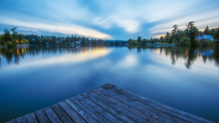Wooden dock on a calm lake at dusk