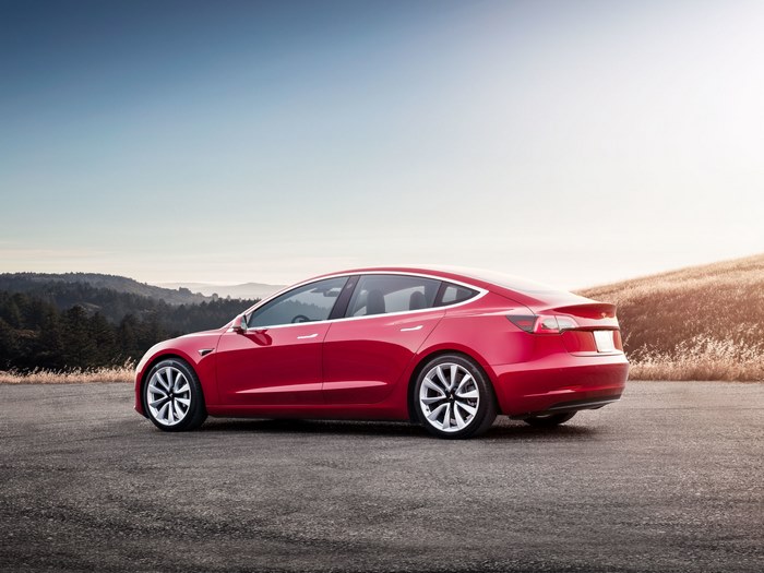 Red Tesla Model 3 on a Road