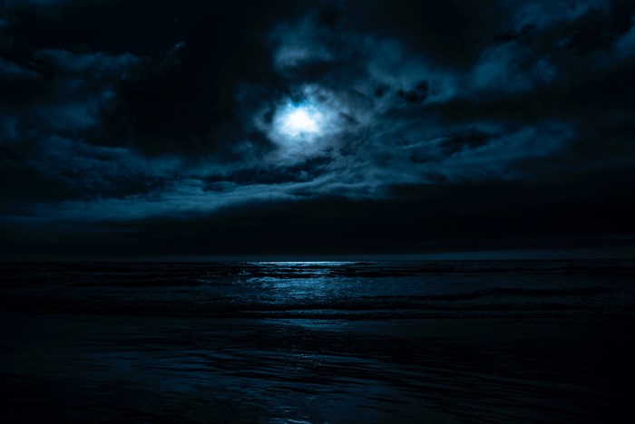 Moonlit Ocean Under Dark Clouds
