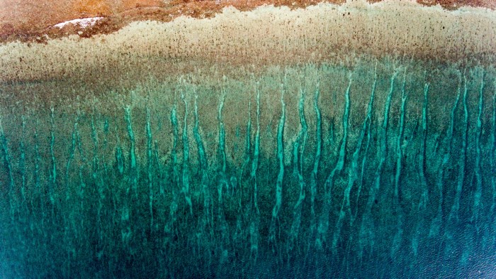 Aerial view of turquoise water and sandy shore