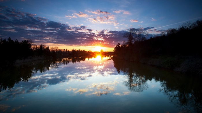 Sunset over a calm lake with reflections