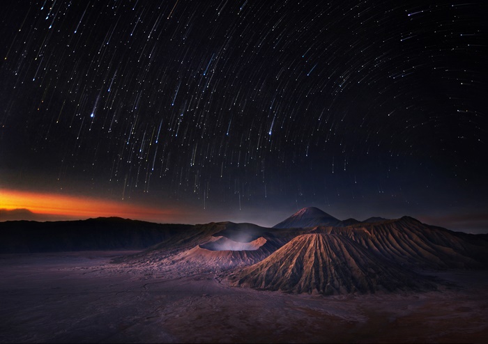 Star trails over volcanic mountains at night