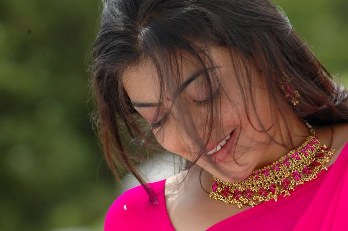 Kajal Agarwal wearing a pink saree and gold necklace