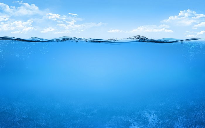 Underwater view of ocean with sky and clouds above