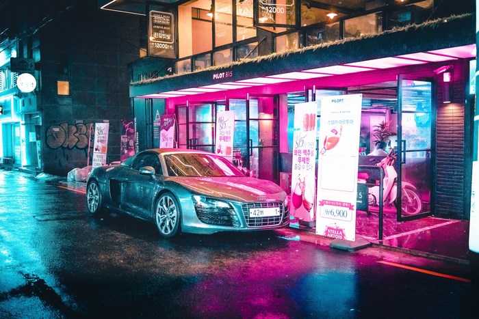 Audi R8 parked in a neon-lit street at night