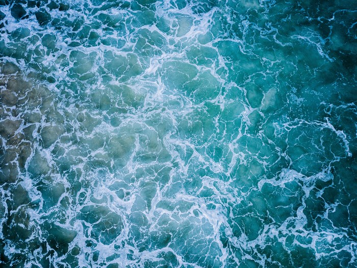 Aerial view of ocean waves and sea foam