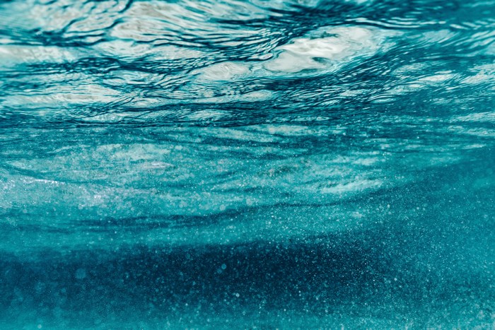Underwater view of turquoise ocean water with ripples and bubbles