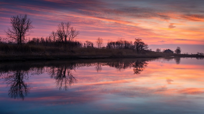 Sunset over a calm lake with reflections