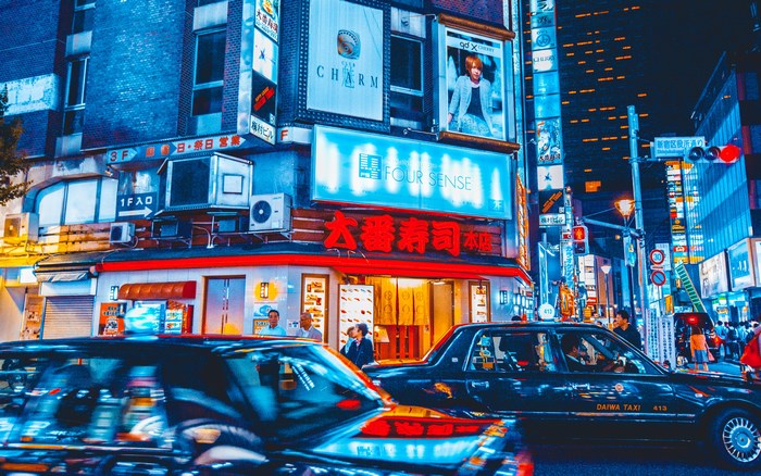 Night street view of Tokyo with taxis and neon signs