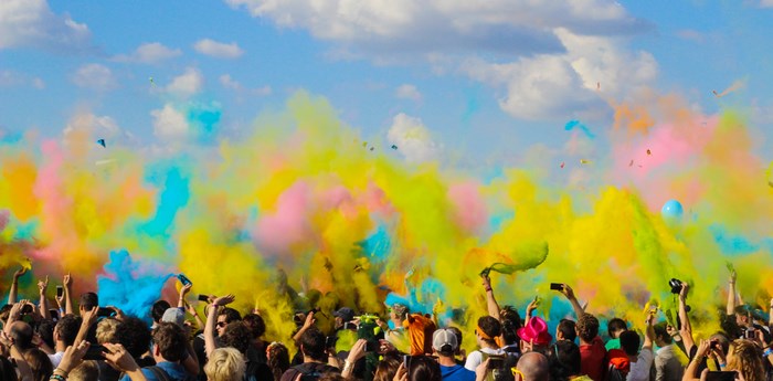 Crowd at a color run festival with colorful powder in the air