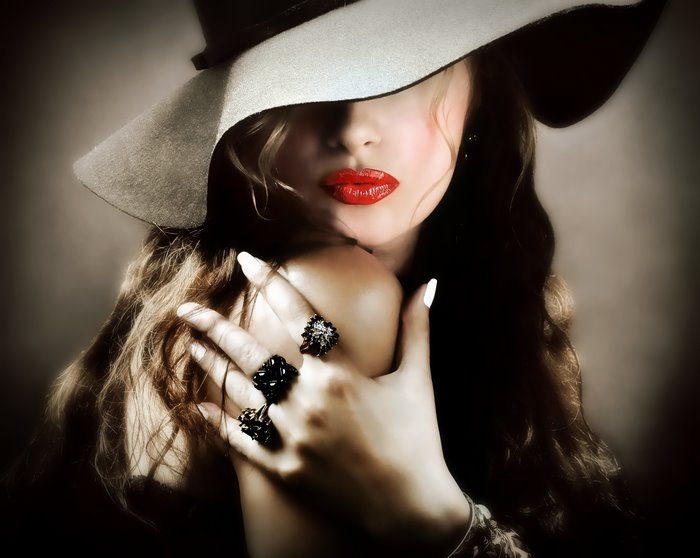 Woman with red lipstick and hat wearing rings