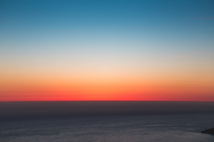 Ocean horizon at sunset with gradient sky