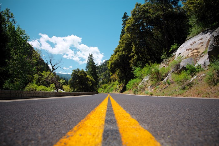 Scenic mountain road with yellow lines and trees