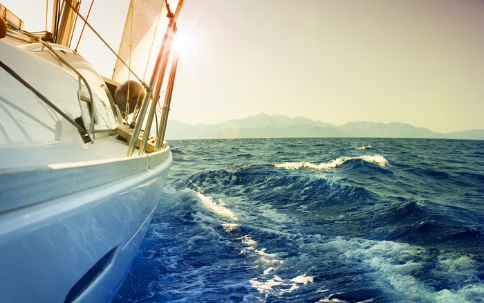 Sailboat on the ocean with mountains in the background