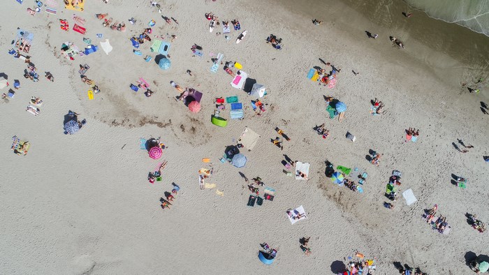 Aerial view of a crowded beach with people sunbathing and umbrellas