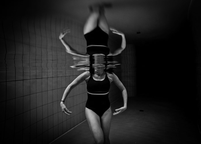 Woman in swimsuit underwater with reflection