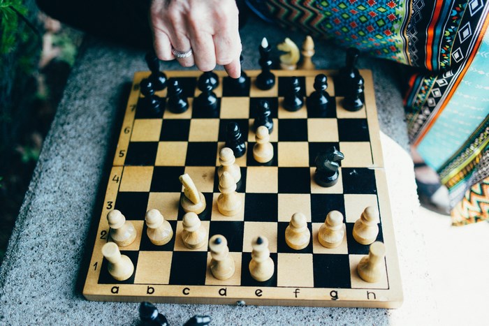 Person playing chess outdoors