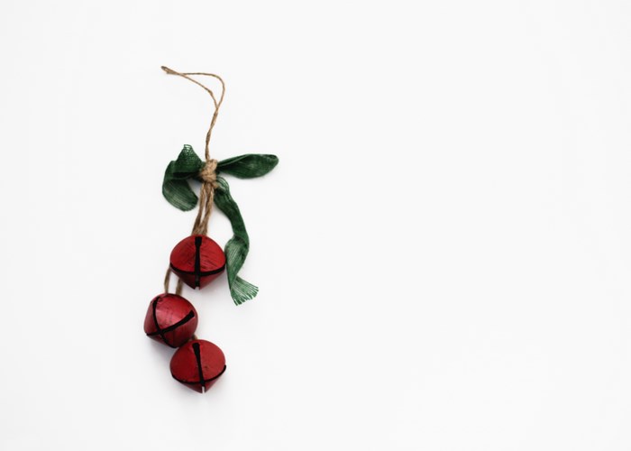 Red Christmas bells with green ribbon on white background