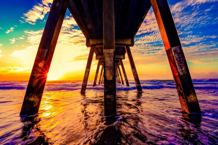 Sunset under a pier with ocean waves