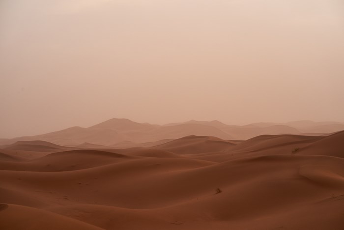 Desert dunes under a hazy sky