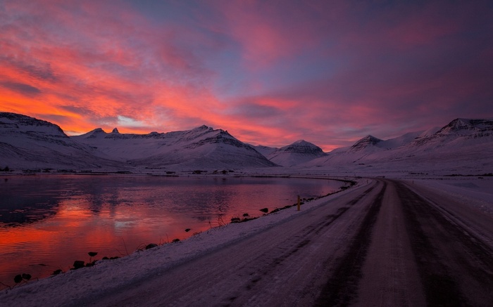 Snowy mountains and a road at sunset