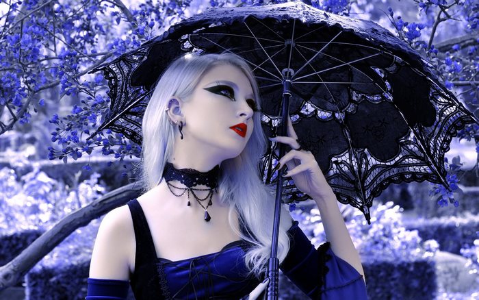 Goth girl with black umbrella and blue flowers