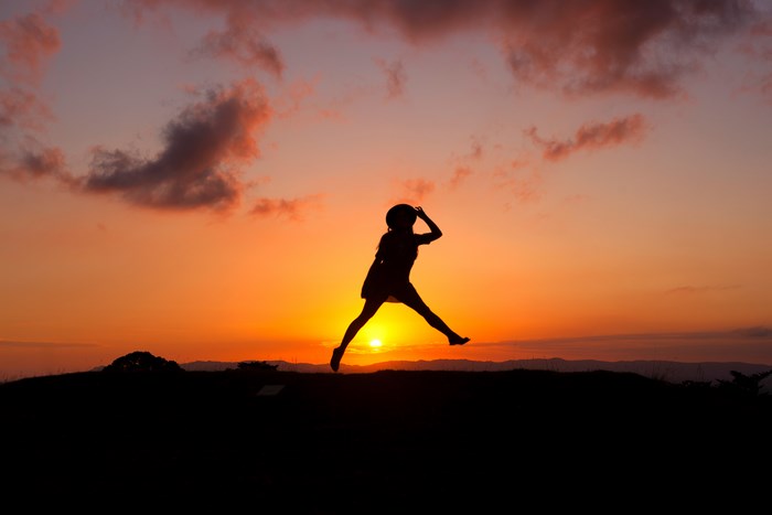 Silhouette of a woman jumping at sunset