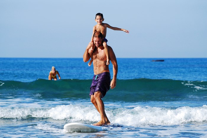 Father and son surfing on a surfboard
