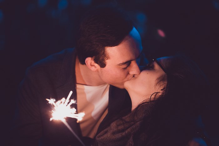 Couple kissing with sparkler at night