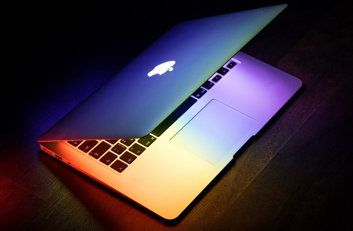 MacBook laptop with rainbow lighting on a wooden table