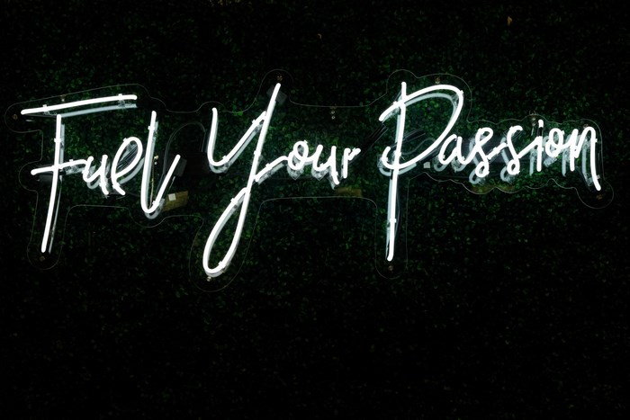 Neon sign "Fuel Your Passion" on a green background