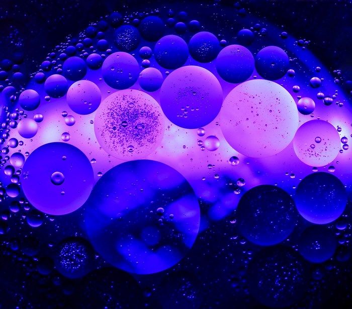 Oil and water bubbles with purple and blue light