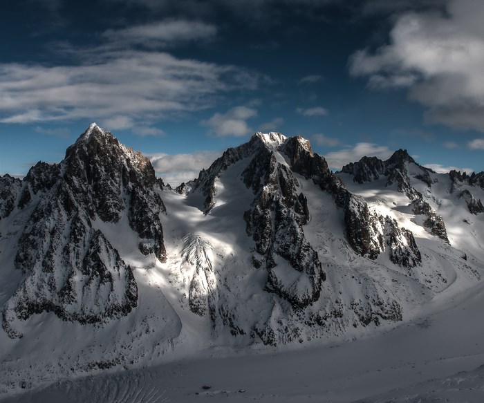 Snow-covered mountain range with dramatic shadows and sunlight