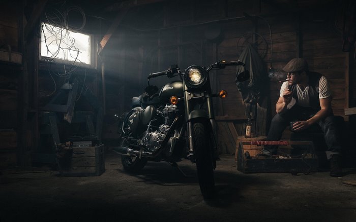 Man smoking in a garage with a motorcycle