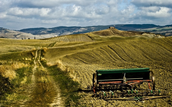 Tuscan landscape with a farm implement and rolling hills