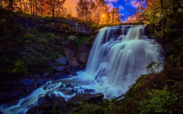 Waterfall cascading through a forest during autumn
