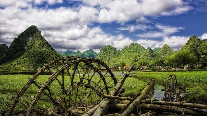 Water wheels in a rural landscape with mountains