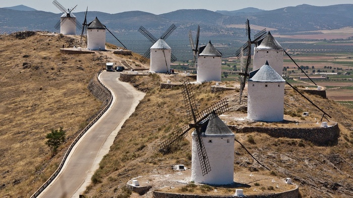 Windmills on a hill with a road and fields