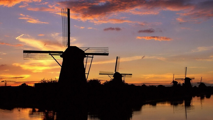Windmills silhouetted against a sunset sky