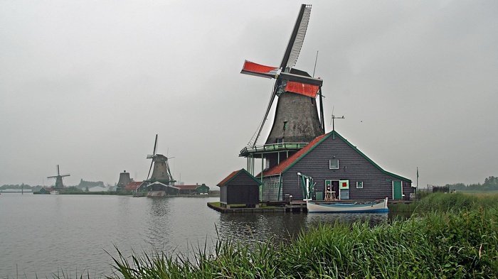 Windmills on a cloudy day by the water