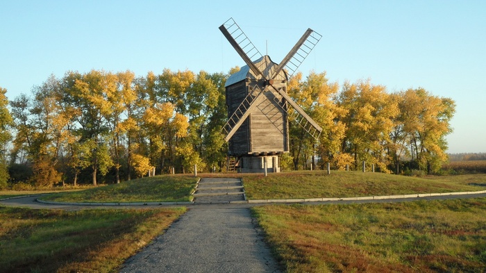 Wooden windmill in autumn landscape