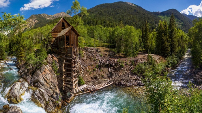 Old wooden mill by a river in the mountains