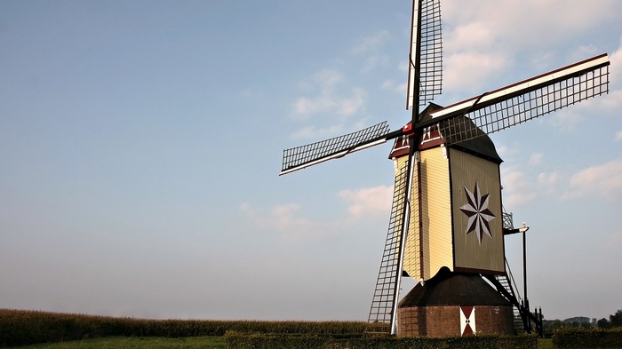 Windmill with large sails against a blue sky